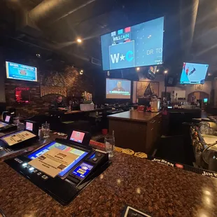 a bar with a lot of tvs on the wall