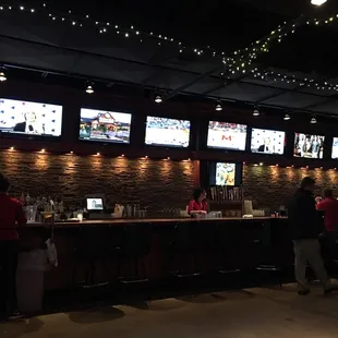 a group of people standing at a bar