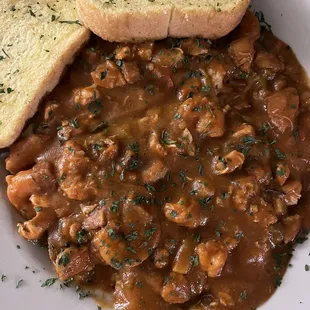 Cajun bowl with shrimp, sausage and chicken over rice with garlic bread