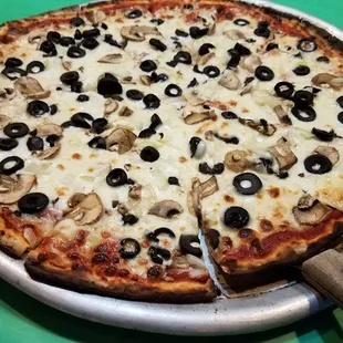 a pizza with olives and mushrooms