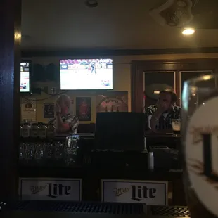 a man sitting at a bar with a glass of beer in front of him