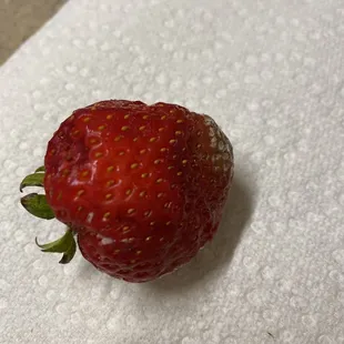 Rotten strawberry on top of a $30 cake.