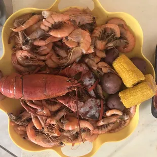 a bowl of lobster, corn and potatoes