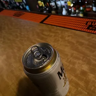 a can of beer on a bar counter