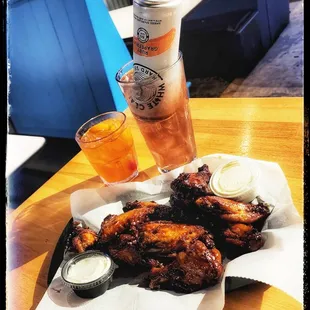 a plate of chicken wings and a drink