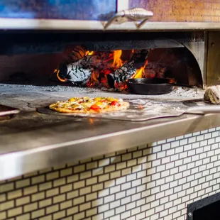 a pizza being cooked in a brick oven