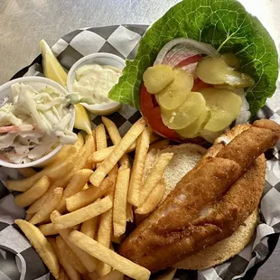 a fish sandwich with fries and coleslaw