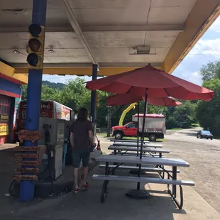 Outdoor seating underneath an old fuel station canopy!