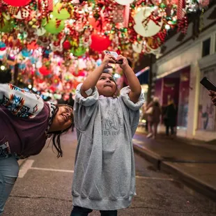 A girl takes a photo under one of the canopies at the Route 66 Christmas Chute.