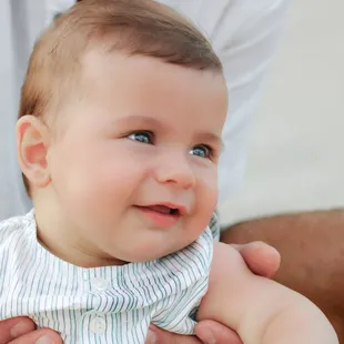 A small baby looking at parents during a photoshoot.