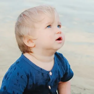 A child gazes towards the sky during a photoshoot