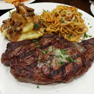 Ribeye steak with garlic noodles and mash potatoes with mushroom gravy. Cooked perfectly. So good!
