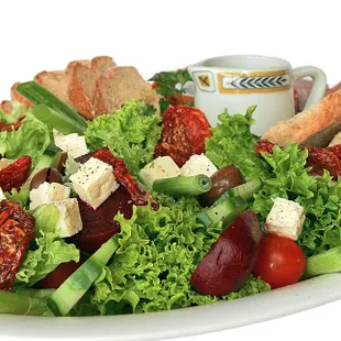 a plate of salad with bread, tomatoes, lettuce, and croutons