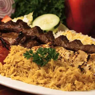a plate of food with rice, meat and vegetables