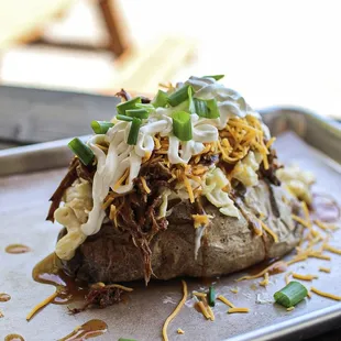  a baked potato topped with shredded cheese and green onions
