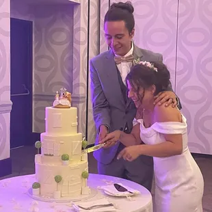 a bride and groom cutting their wedding cake