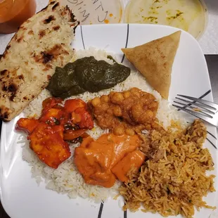 Clockwise from one o&apos;clock: veggie samosa, channa masala, chicken biryani, chicken Tikka masala, chicken 65, garlic Naan, lamb palak