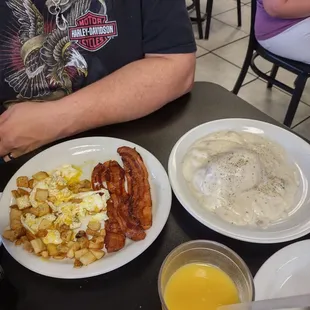 Side order of biscuits and gravy with hash browns and eggs and bacon.