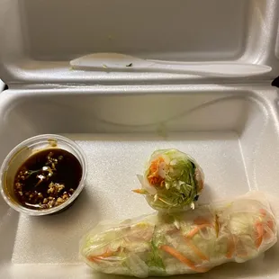 a tray with a roll and a bowl of dipping sauce