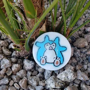 a blue and white cat sitting on a rock