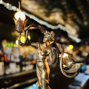 a statue of a lady holding a lamp