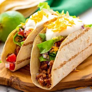 two tacos on a cutting board