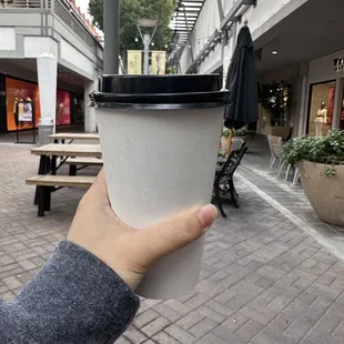 a hand holding a cup of coffee