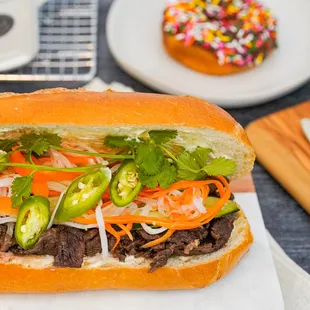 a beef sandwich with carrots and jalapenos