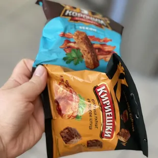 a hand holding a bag of chips