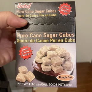 a hand holding a box of sugar cubes