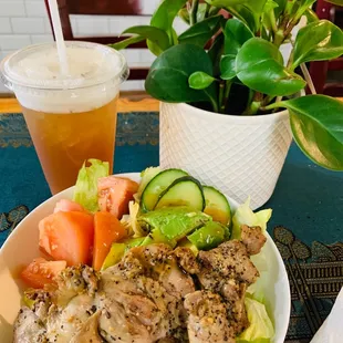 a bowl of chicken, lettuce, tomato, cucumber, and cucumber