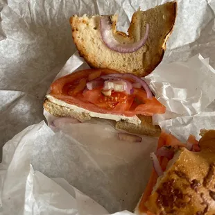 a half eaten sandwich on a piece of paper