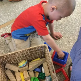 a toddler playing with wooden blocks