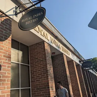 a man standing in front of a brick building