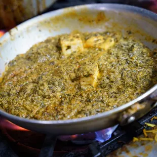 a pan of food cooking over a fire