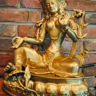 a statue of a woman seated on a lotus