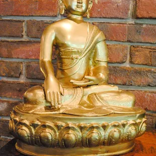 a golden buddha statue on a wooden table