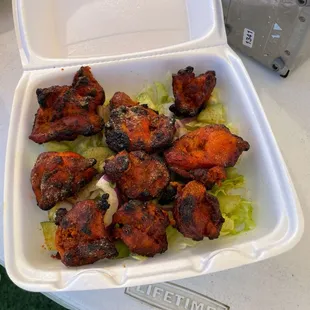 chicken wings and lettuce in a styrofoam container
