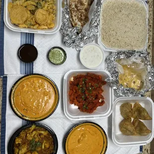veg pakora, naan, basmati rice, Makki di Roti, Veg Samosas, Nav Ratan Korma, chicken 65, aloo gobhi, and paneer tikka masala