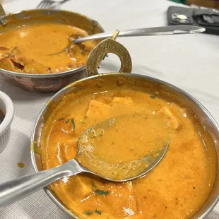 two bowls of curry and a spoon