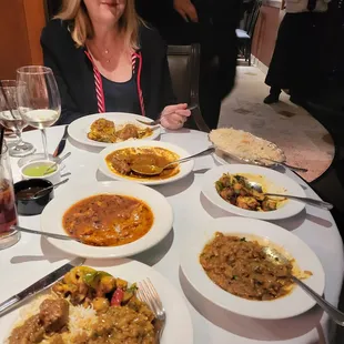 a woman sitting at a table full of food