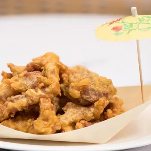 a plate of fried food with a paper umbrella