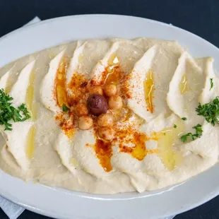 a plate of hummusle with a spoon