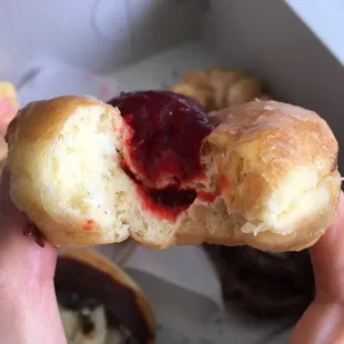 Huge pile of raspberry jelly on top and filled inside the donut!