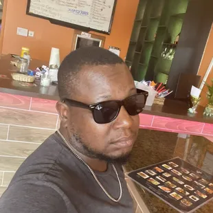 a man in sunglasses sitting at a counter