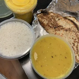 Mango lassi top left - came wrapped in seran wrap to prevent spillage in takeout bag. Pista coconut naan and dal tadka on right