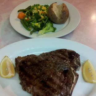T bone steak with baked potato and vegetables