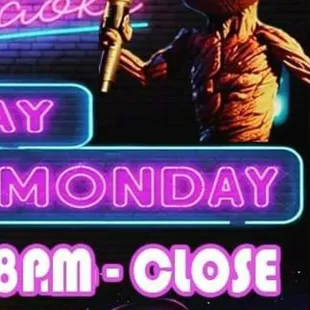 a grooter holding a microphone in front of a neon sign