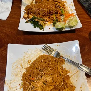 two plates of noodles and a fork