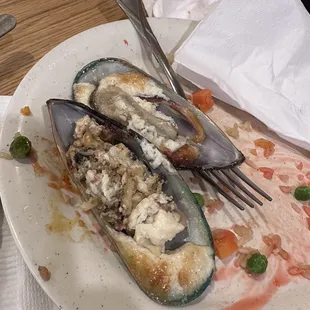 two musselling mussellings on a plate with a fork